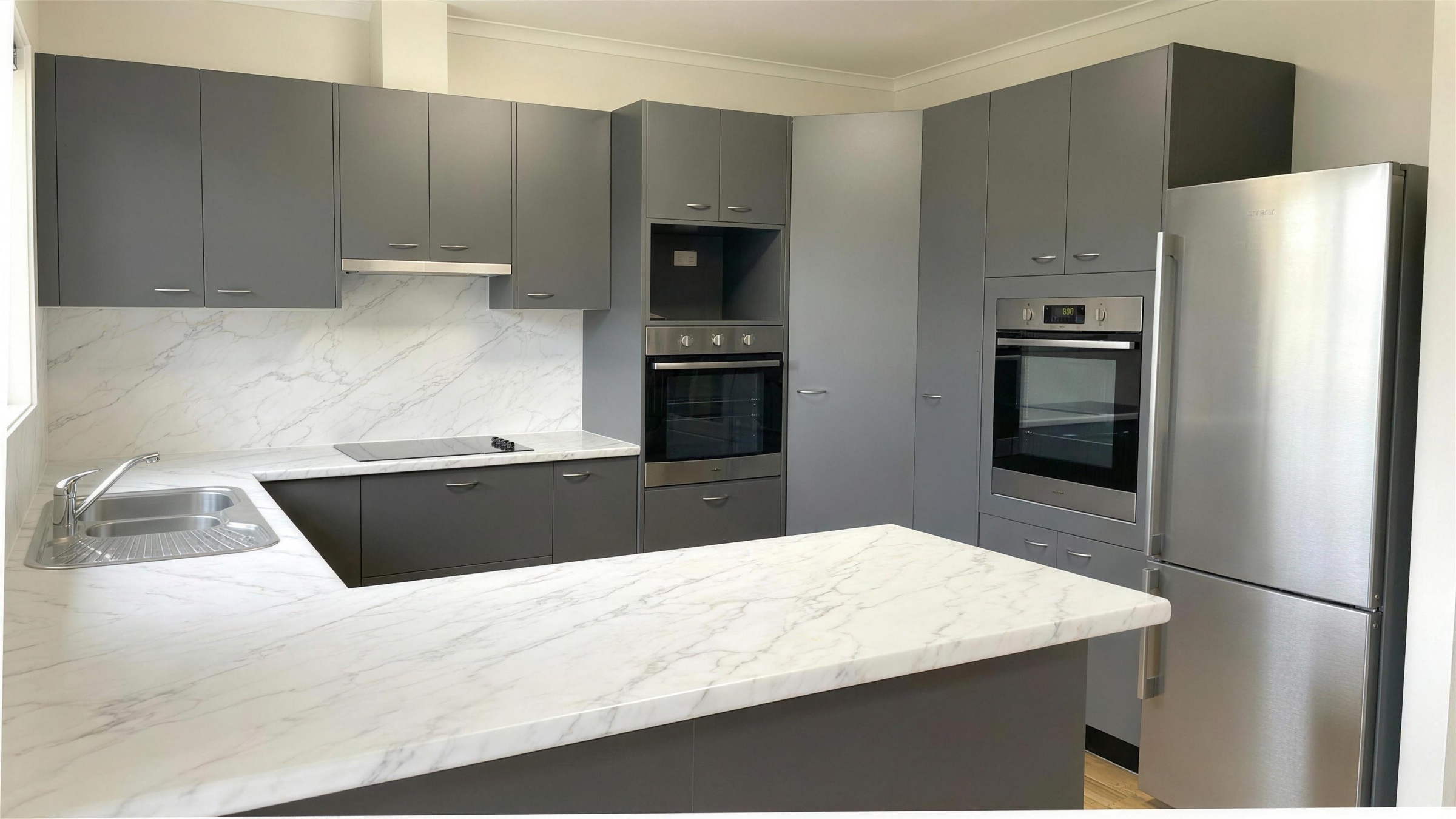 Cuisine rénovée, façades anthracite et plan marbre